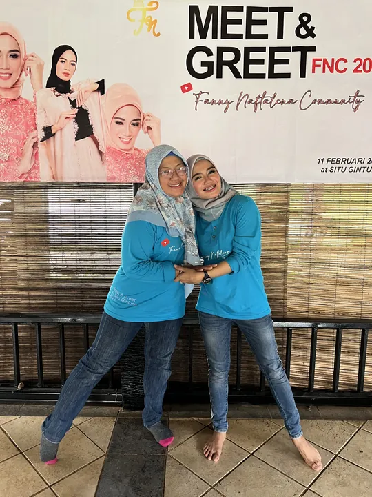 Dua anggota FNC berfoto di depan backdrop Meet & Greet FNC 2023