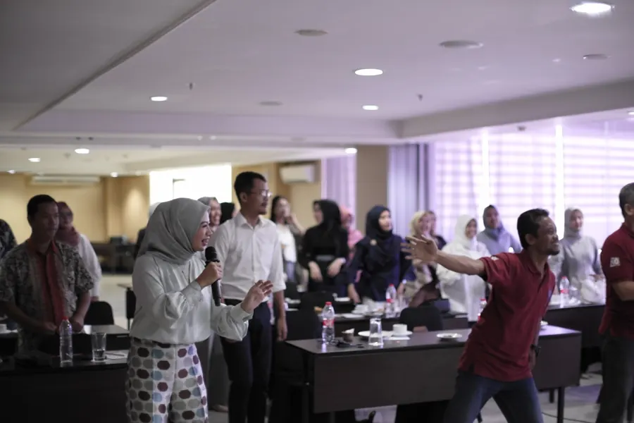 Peserta PT BPR Sahabat Sejati berdiri dan mengikuti sesi energizer bersama Fanny Naftalena